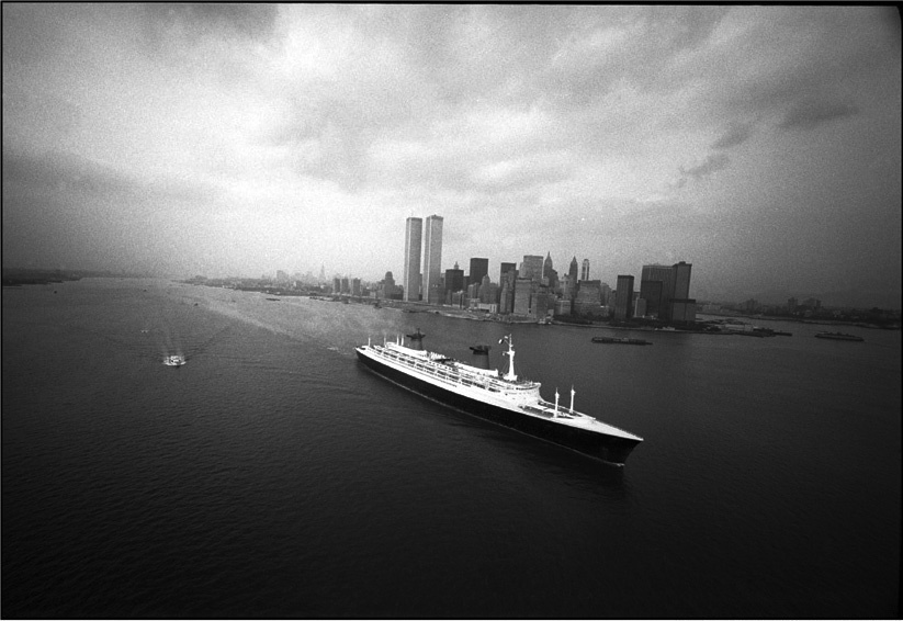 the SS France leaves NY harbour for the last time, passing the newly opened World Trade Center  1974 : Too Close UMFA : David Burnett | Photographer