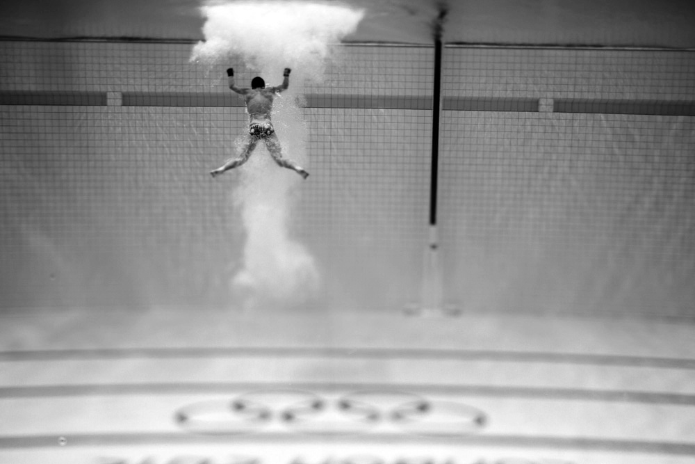 A diver, heads out of the water.