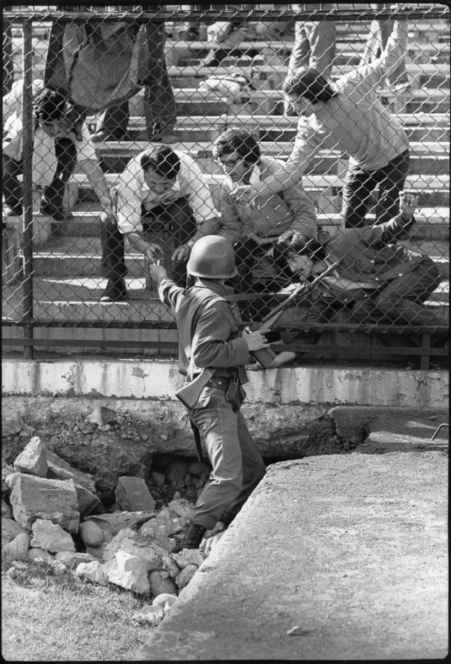Journalists throw cigarettes to political prisoners at the National stadium