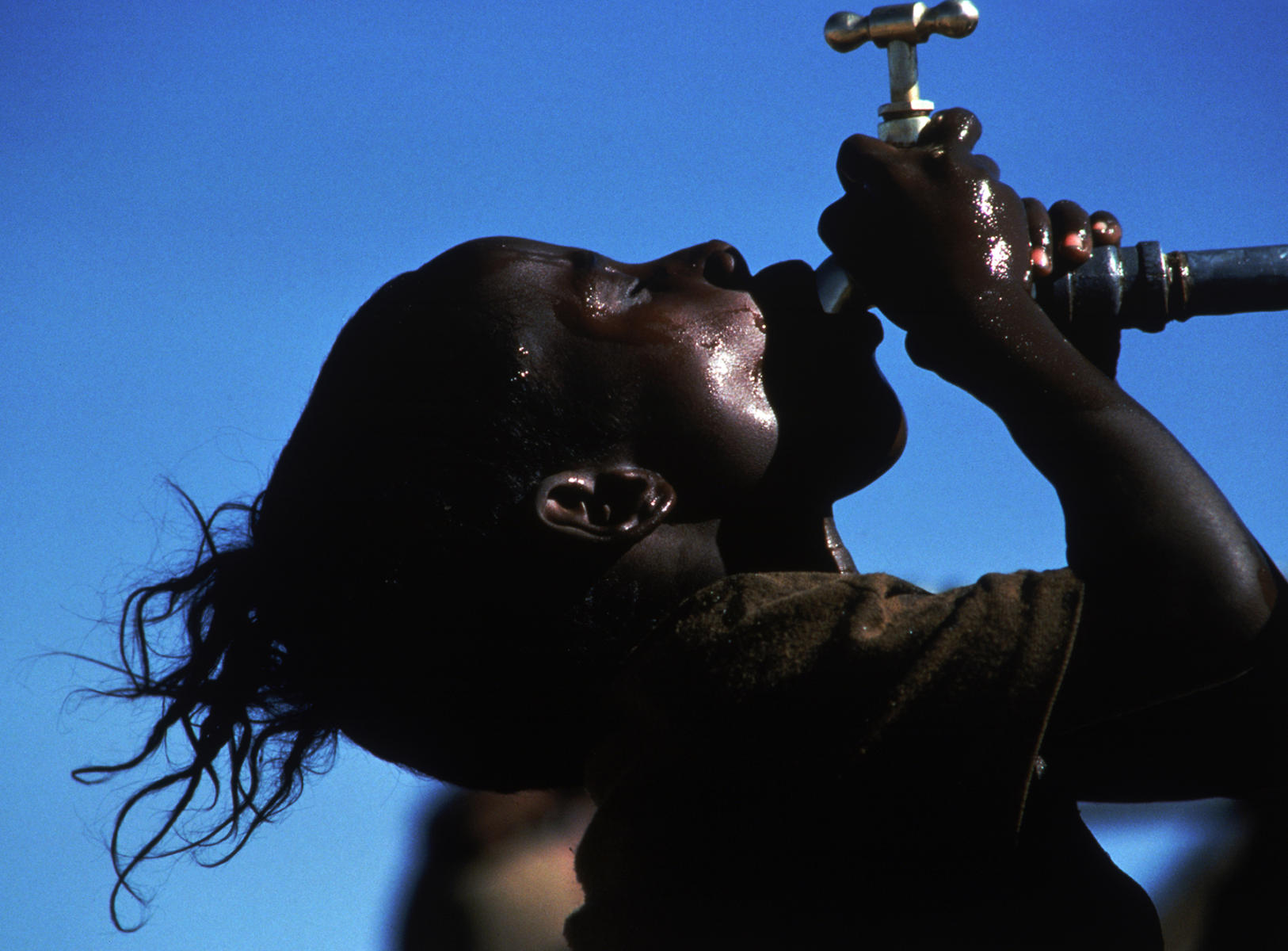 A young boy goes for the last drop of water in the Korem Refugee Camp, Ethiopia 1984 : Looking Back: 60 Years of Photographs : David Burnett | Photographer