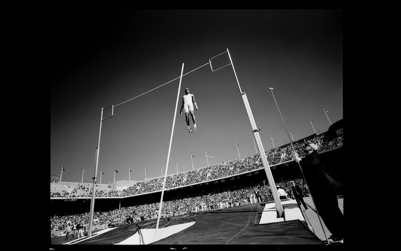 Pole vault record holder Lawrence Johnson goes over the bar: Penn Relays 1996 : Looking Back: 60 Years of Photographs : David Burnett | Photographer