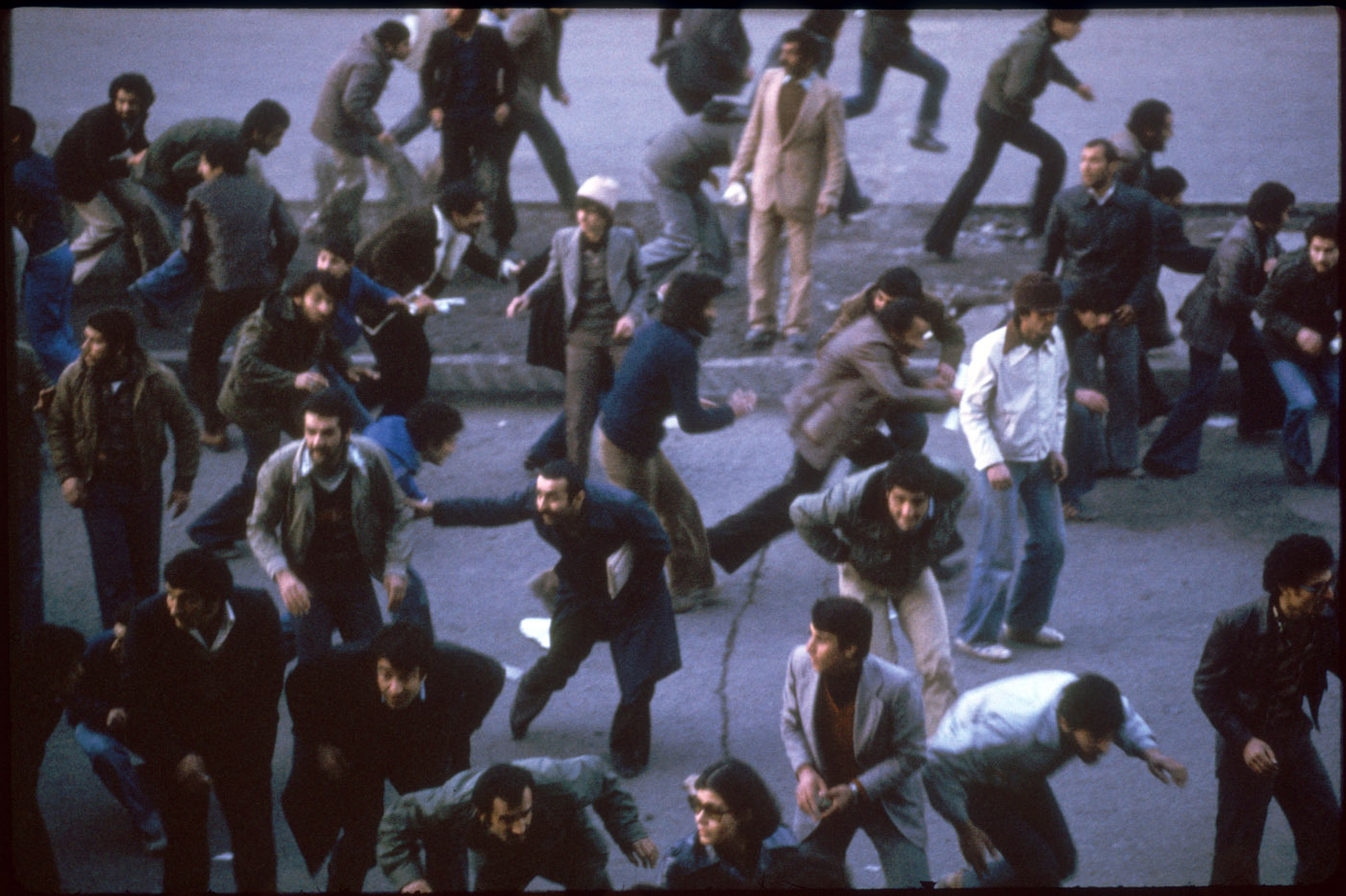 Watching crowds scatter when police gunfire erupts. : 44 Days: the Iranian Revolution : David Burnett | Photographer