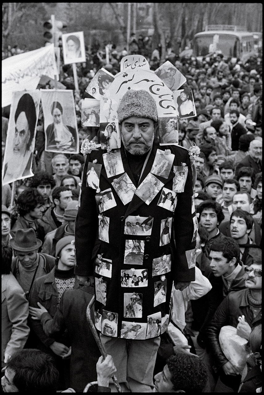 An anti-Shah demonstrator at a Tehran rally. The pictures are snapshots of SAVAK secret police victims. : 44 Days: the Iranian Revolution : David Burnett | Photographer