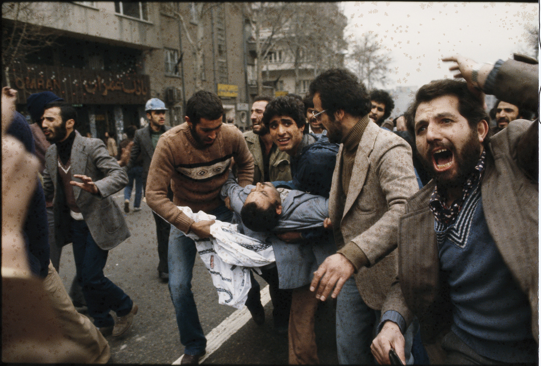 Wounded demonstrators are carried to an ambulance.