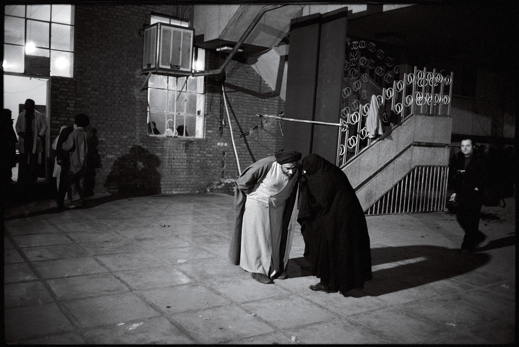 In the courtyard of the Refa school, members of Khomeini's entourage confer. : 44 Days: the Iranian Revolution : David Burnett | Photographer